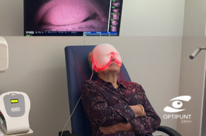 Mujer recibiendo tratamiento de ojo seco con máscara de luz roja modulada en Optipunt