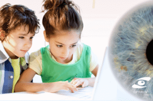 Niños usando ordenador con expresión concentrada, simbolizando el riesgo de miopía infantil por uso de pantallas.