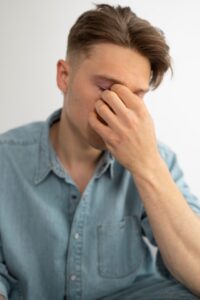 Hombre joven con ojo seco masajéandose los ojos