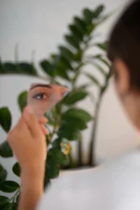 Mujer joven viéndose a través de un espejo mientras muestra preocupación por su percepción visual