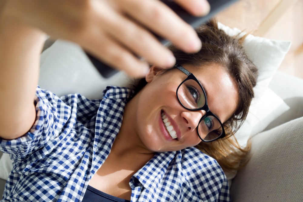 mujer joven de 30 años haciéndose un selfie para presumir de sus nuevas gafas progresivas